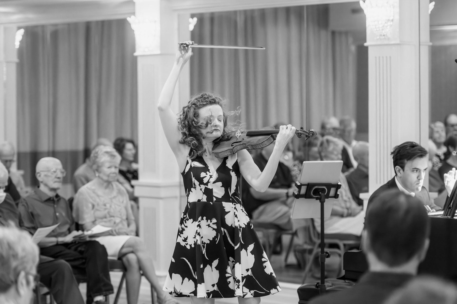 A violinist raising the bow during a performance